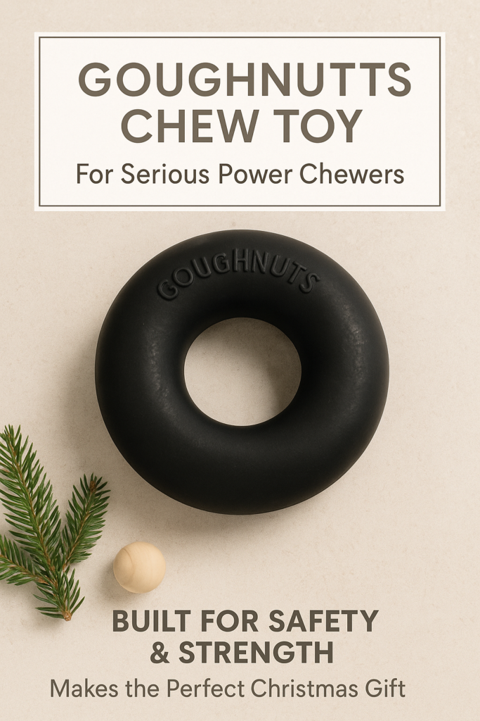 Christmas flatlay of a Goughnuts chew toy on a neutral beige background with subtle evergreen decoration.